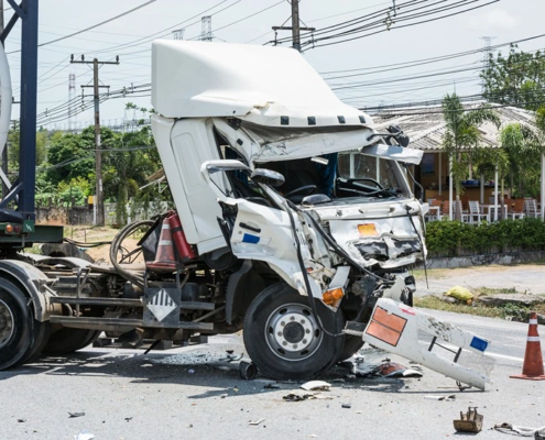 A truck full of chemicals in the middle of the road after a common type of truck accident.